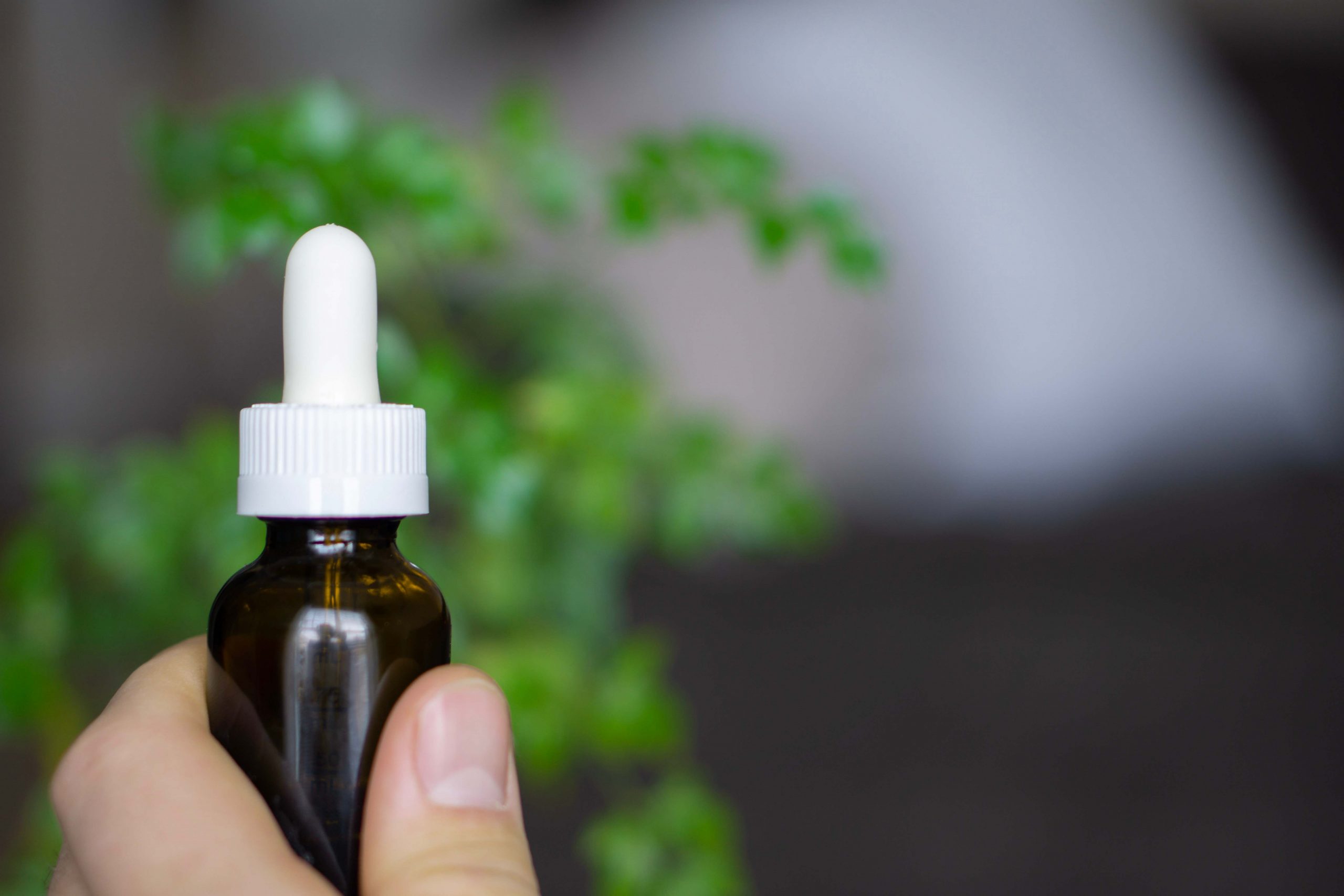 hand holding small bottle of oil