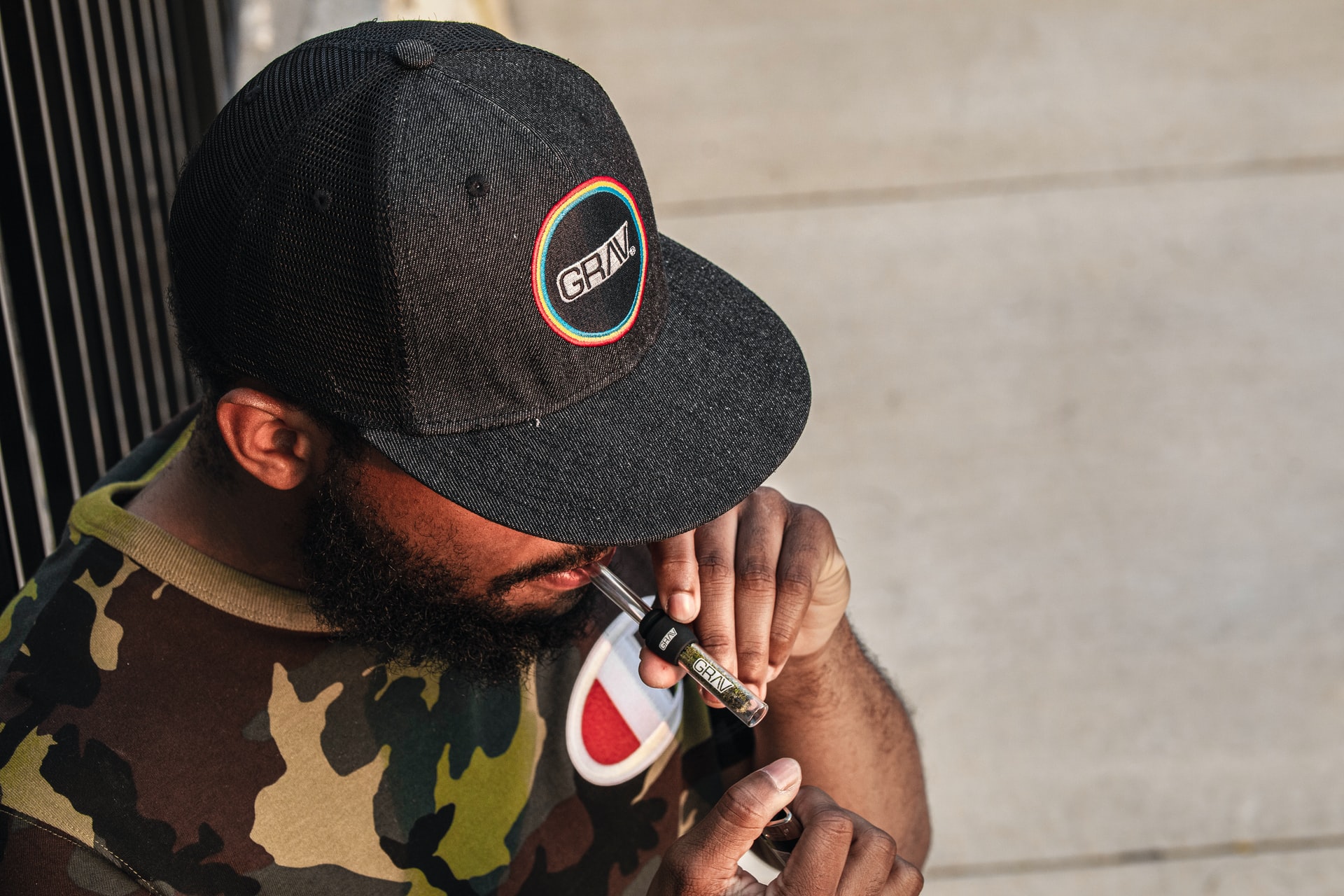 man in black cap smoking joint
