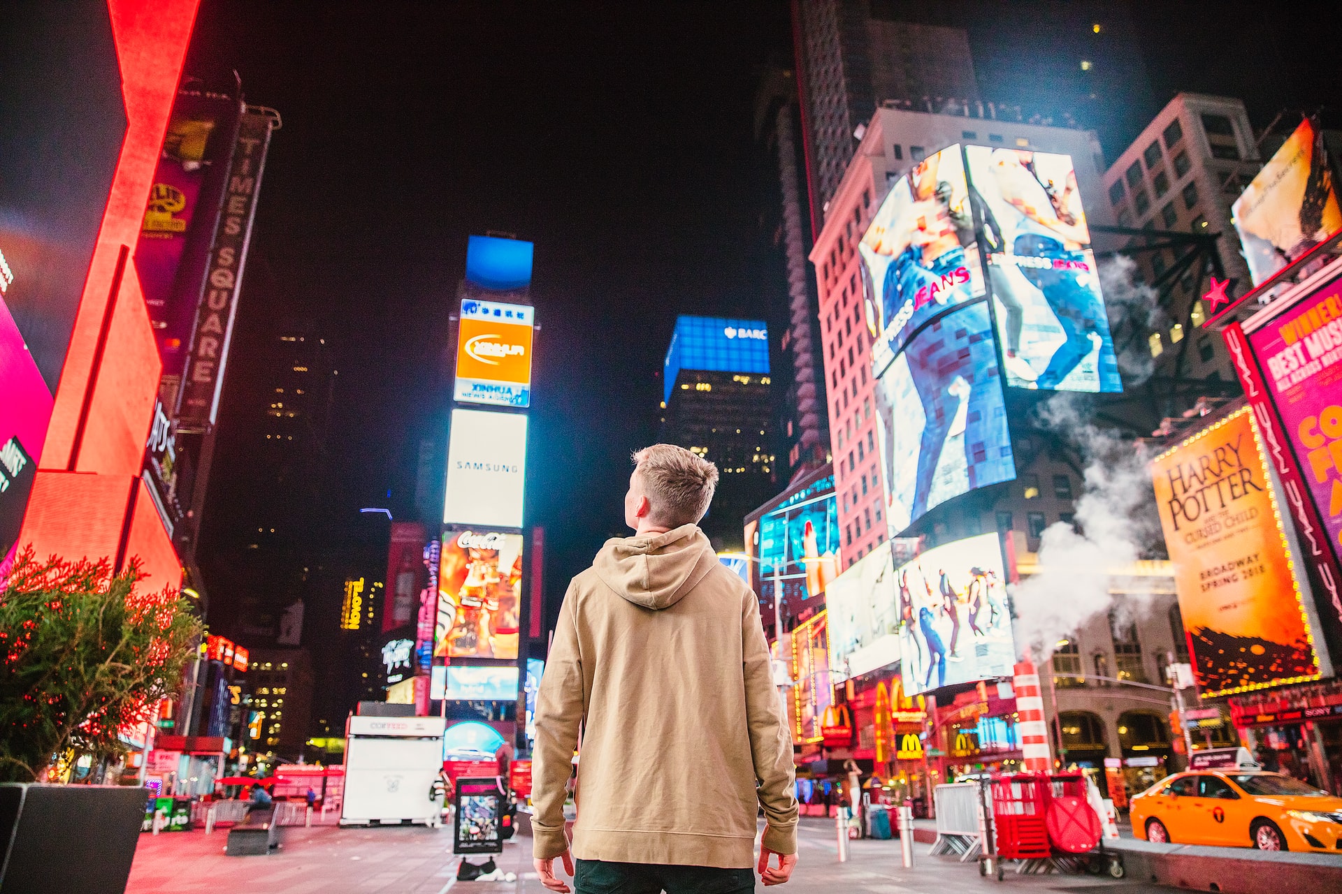 man walking in Times Square NYC at night