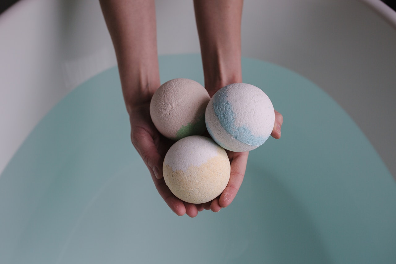 hand holding out three bath bombs