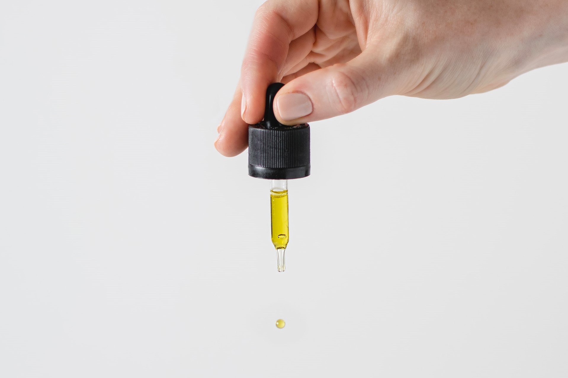 hand holding small oil dropper