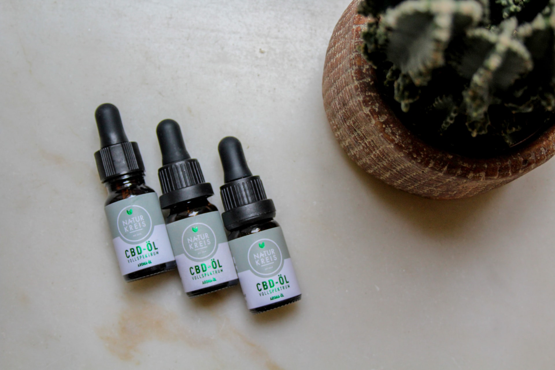 three small bottles of CBD oil on table