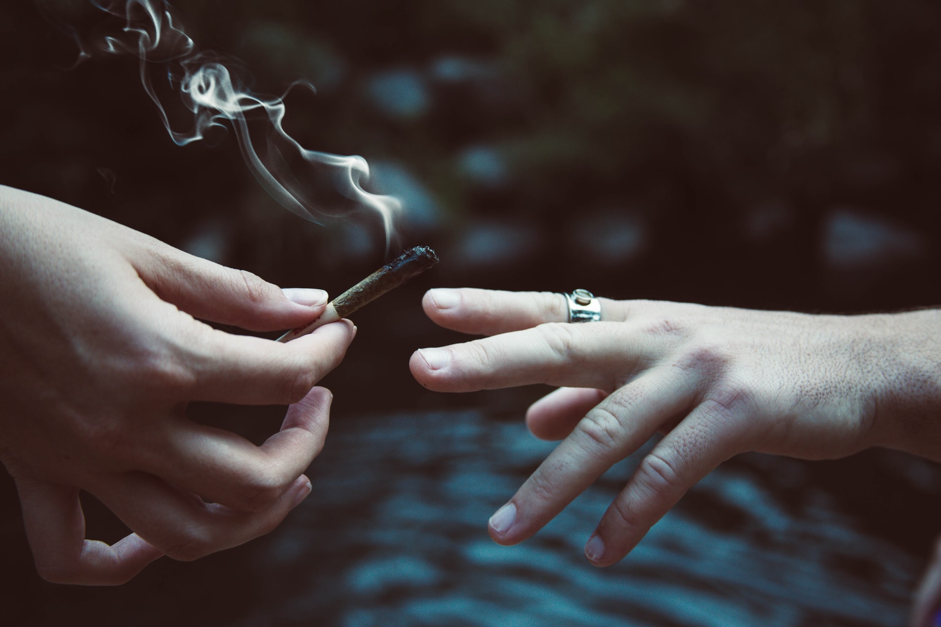 two hands passing a joint